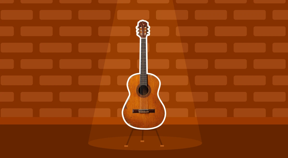 Acoustic guitar on a stand under a spotlight against a red brick wall background, symbolizing learning a new skill through deliberate practice